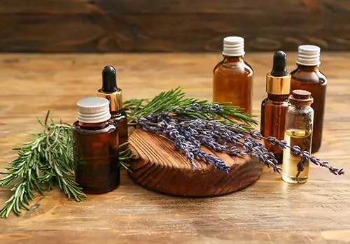 Bottles of natural essential oils on wooden background 