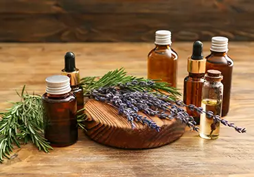 Bottles of natural essential oils on wooden background