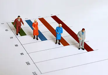 The concept of an increasing elderly population. Miniature old people walking on the graph.