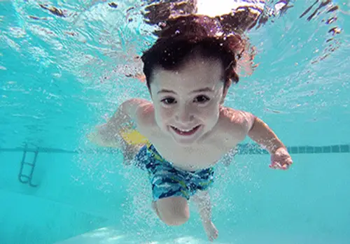 a boy swimming in a pool