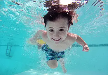 a boy swimming in a pool