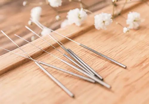 Stand with closeup acupuncture needles on wooden background