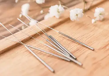 Stand with closeup acupuncture needles on wooden background