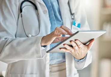 Doctor, office and tablet for research, email or communication. Medic, hospital and reading article, data or health magazine on web, while working with technology in healthcare center or clinic