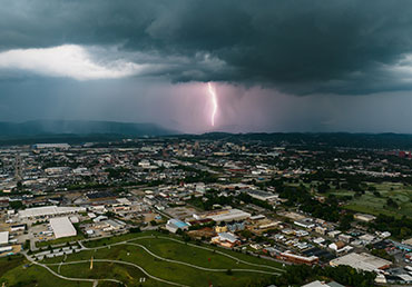 Lightning is seen striking near a city.