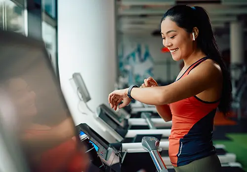 woman exercising and looking at her fitness tracker