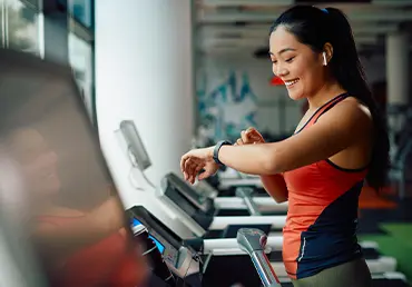 woman exercising and looking at her fitness tracker