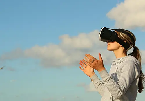 A woman uses virtual reality outdoors.