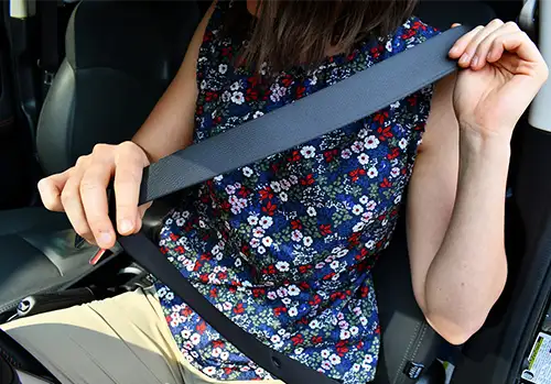 woman-putting-on-seat-belt