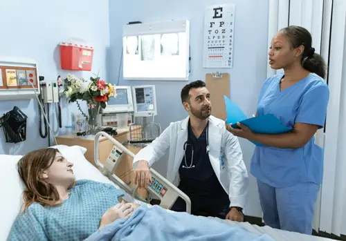 doctor-and-medical-assistant-talking-with-patient-in-her-hospital-bed