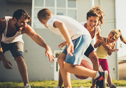 mom and dad playing basketball with their kids