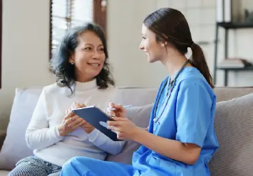 woman and nurse sitting and talking smiling thumbnail image