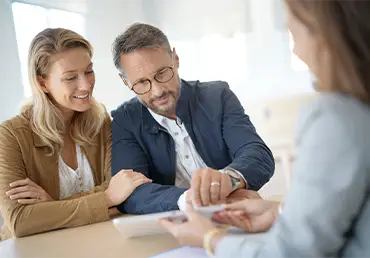 Couple reviewing health insurance documents with an agent, learning what is an HMO