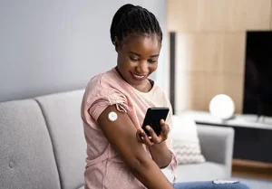 Woman Testing Glucose Level With Continuous Glucose Monitor.
