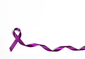 Purple epilepsy awareness ribbon on a white background with copy space.