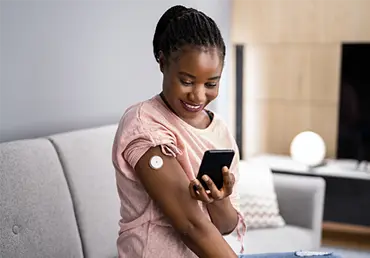 Woman Testing Glucose Level With Continuous Glucose Monitor.